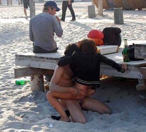 This dissolute girls and guys fuck in public right on the beach